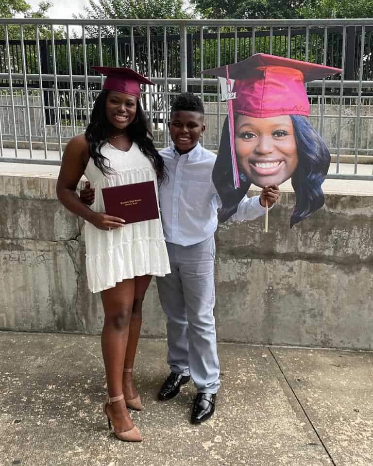 College graduate and brother celebrating her graduation with a BigHead.