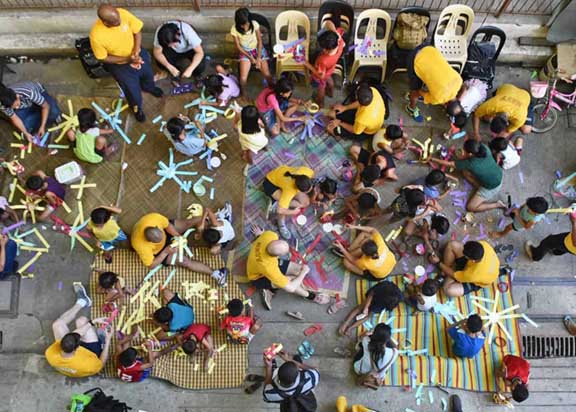 US Navy Sailors making arts and crafts with children in Manila.